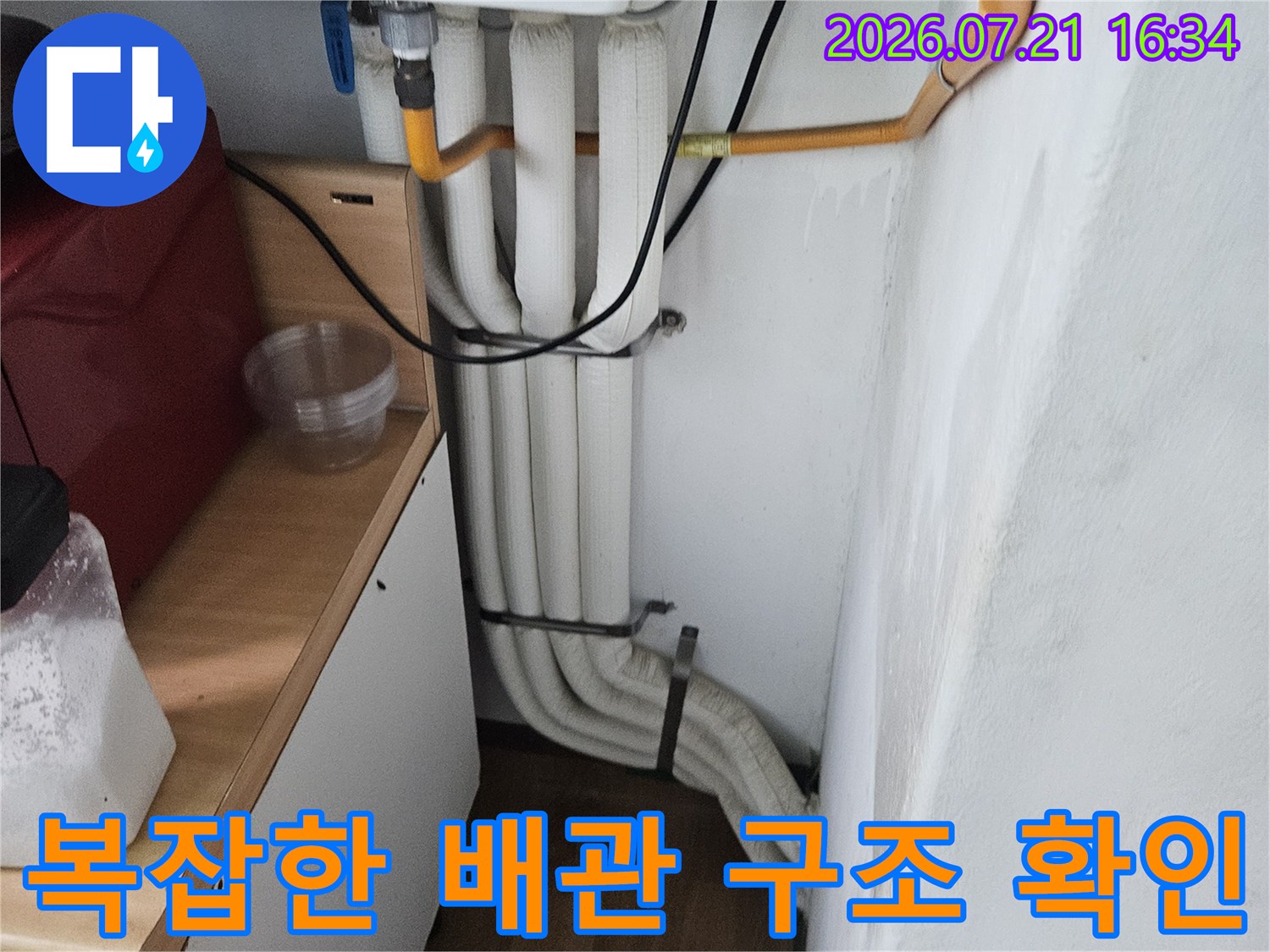 세면대 하부의 복잡하게 얽힌 수도배관 및 연결 부위 점검