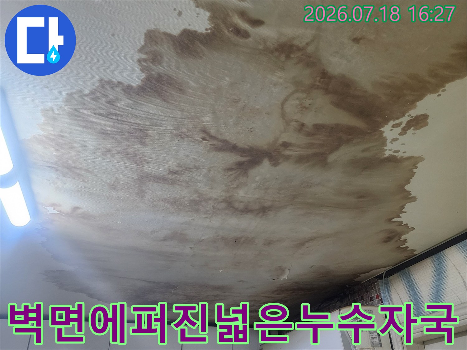 흰색 벽지가 누수로 인해 갈색으로 심하게 오염된 모습-에어컨 설치 부위
