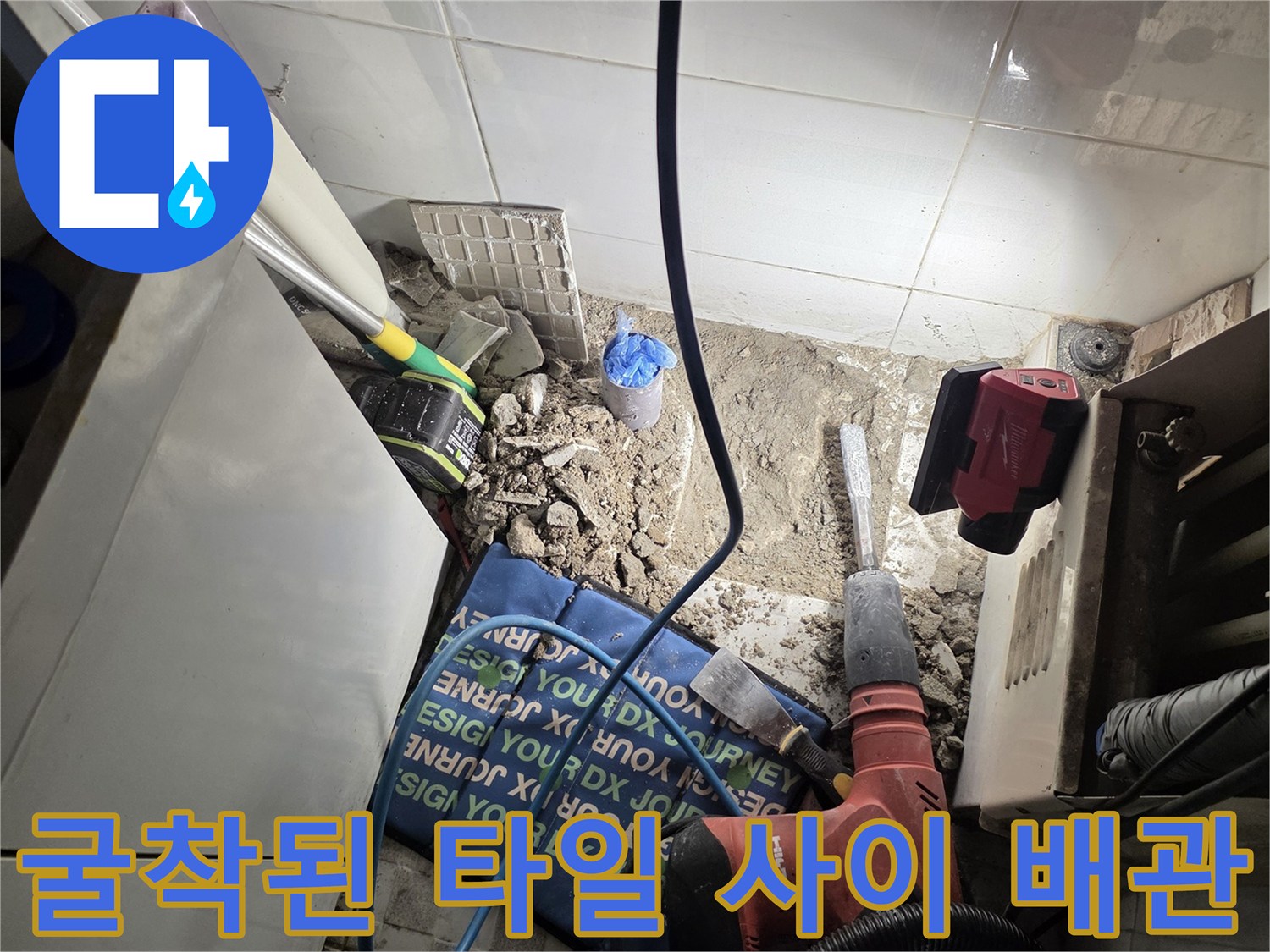 드릴 작업으로 타일을 걷어내고 배관을 노출시킨 공사 현장