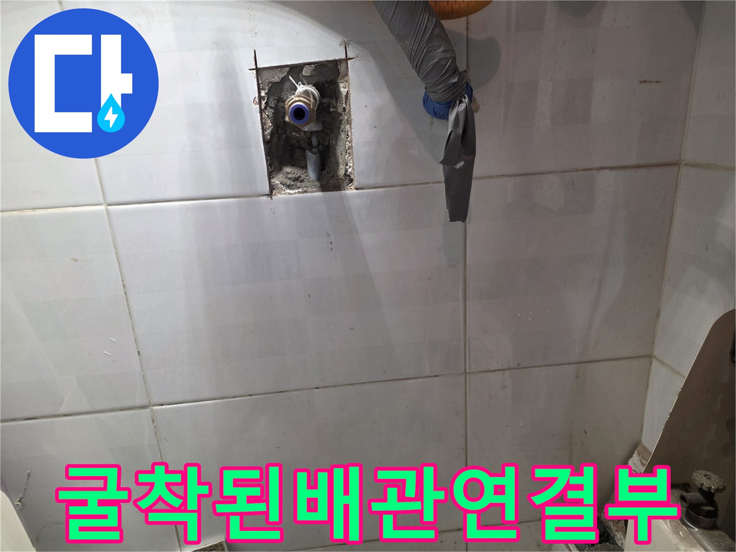 벽돌과 타일 사이 노출된 금속 수도 배관