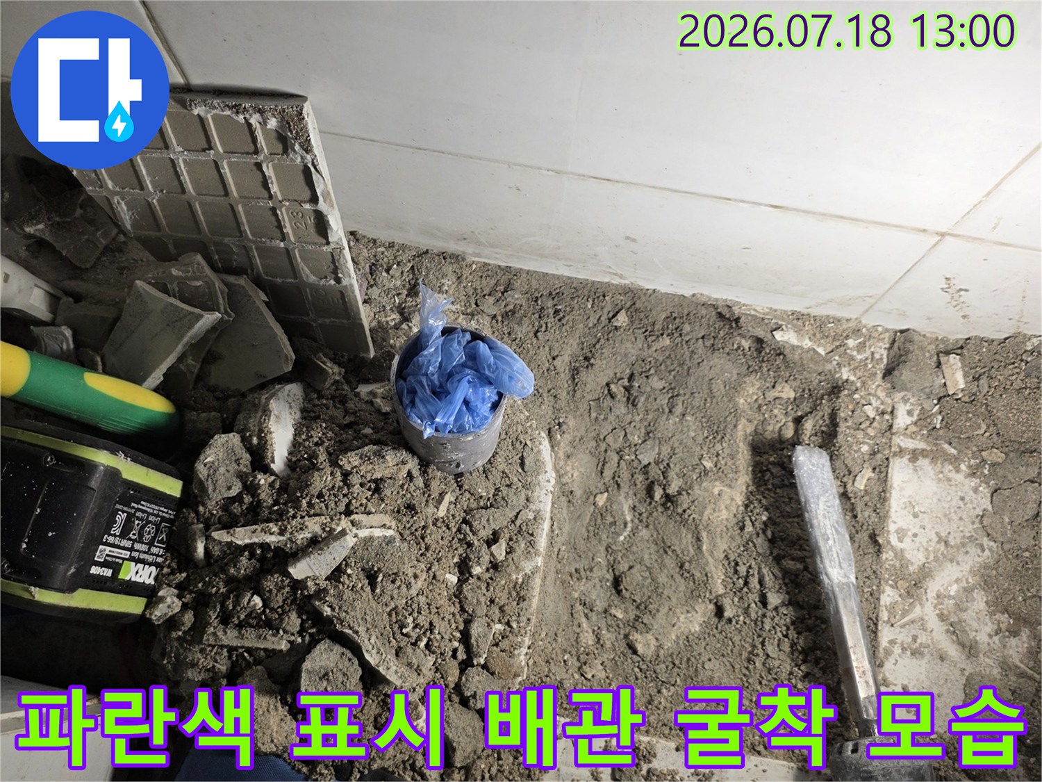 작업 도구와 함께 바닥면이 파헤쳐져 있고 누수 부위 배관이 노출된 현장 사진