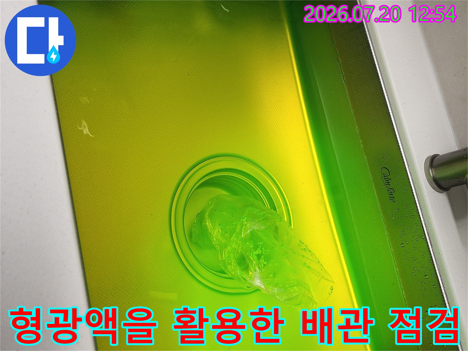 싱크대 내부에 채워진 노란색 형광 염료와 중앙 배수구의 모습-누수 진단 작업 사진-사진