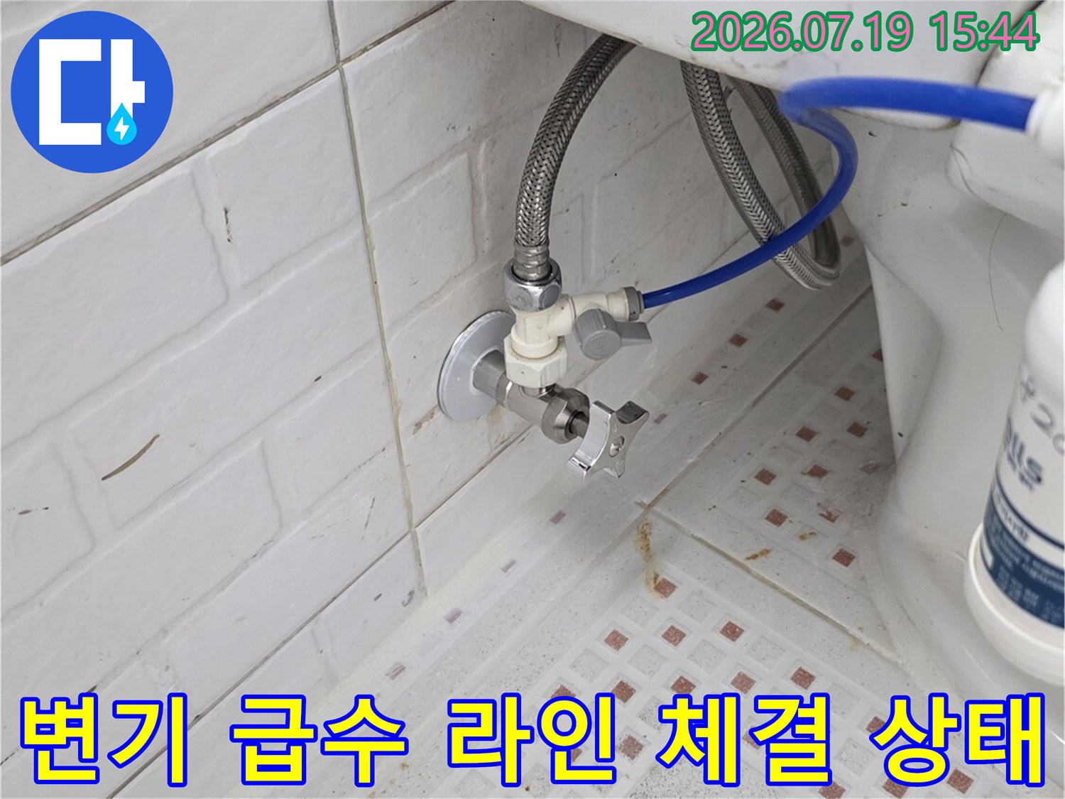 벽면 타일에 설치된 변기 앵글밸브와 파란색 공급 호스-연결 부위 근접샷