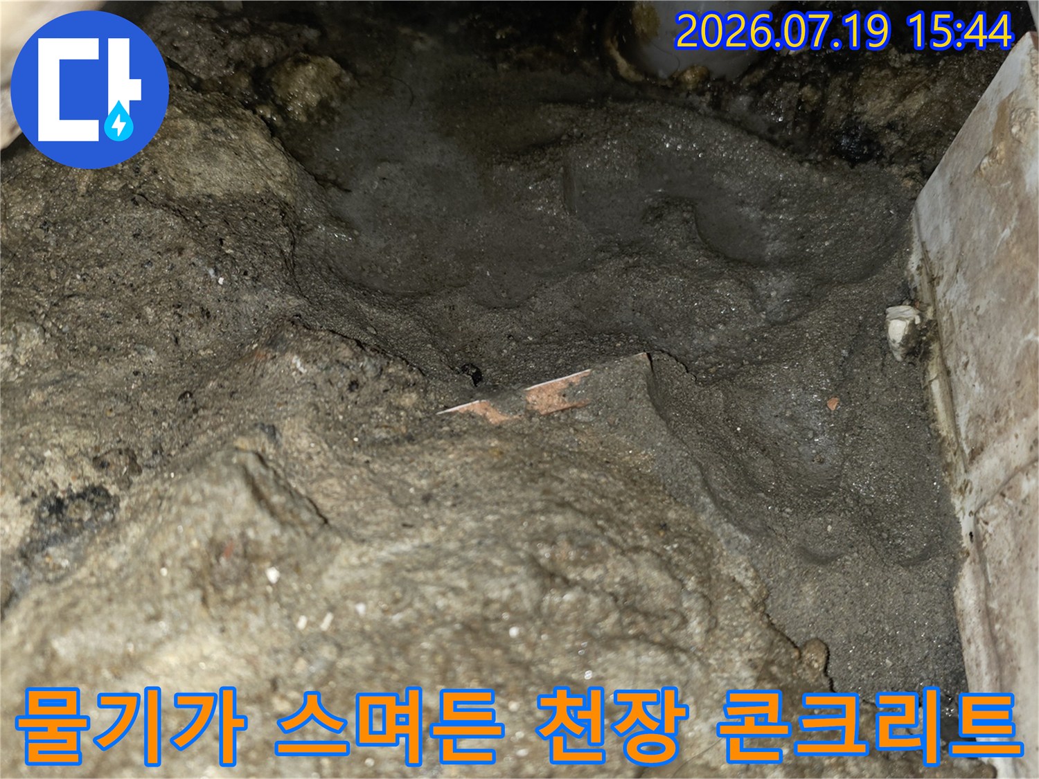 습기로 인해 색이 짙어지고 표면이 거칠어진 화장실 천장의 슬라브 모습