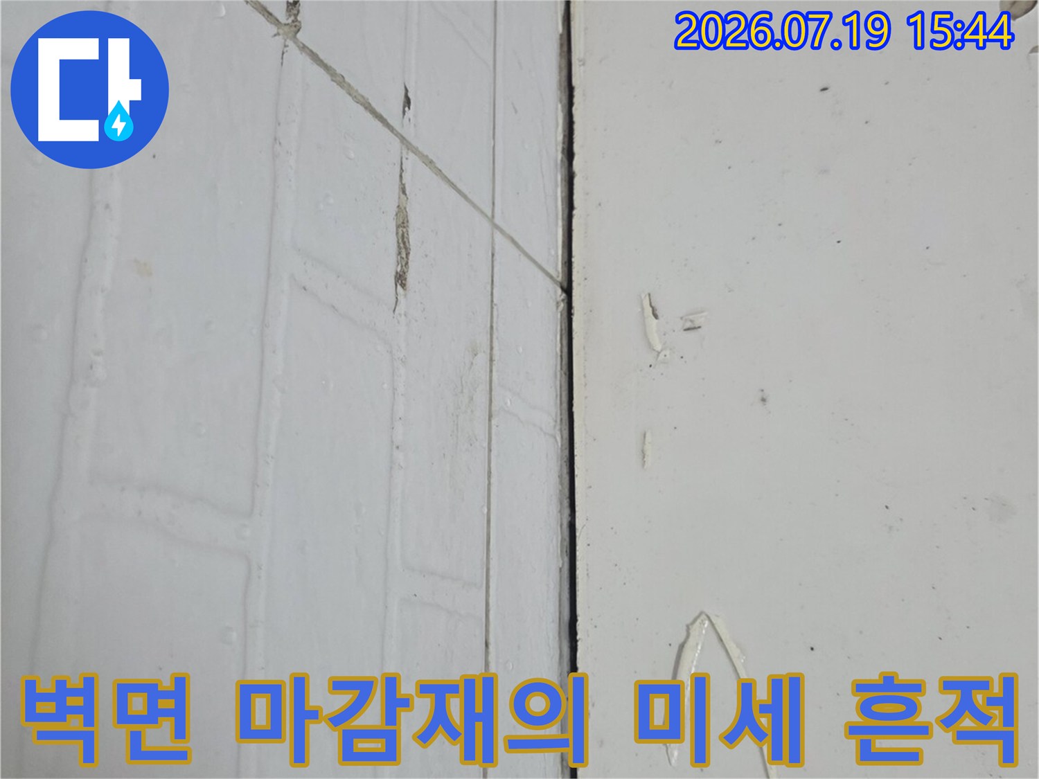 흰색-화장실-벽체에-남은-작은-오염점들과-V자형-스크래치-부위