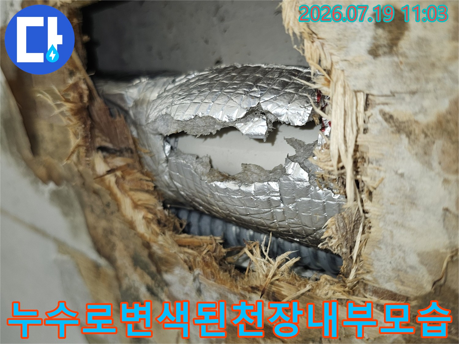 물에 젖어 변색된 천장 마감재와 은색 보온재가 처리된 배관의 사진