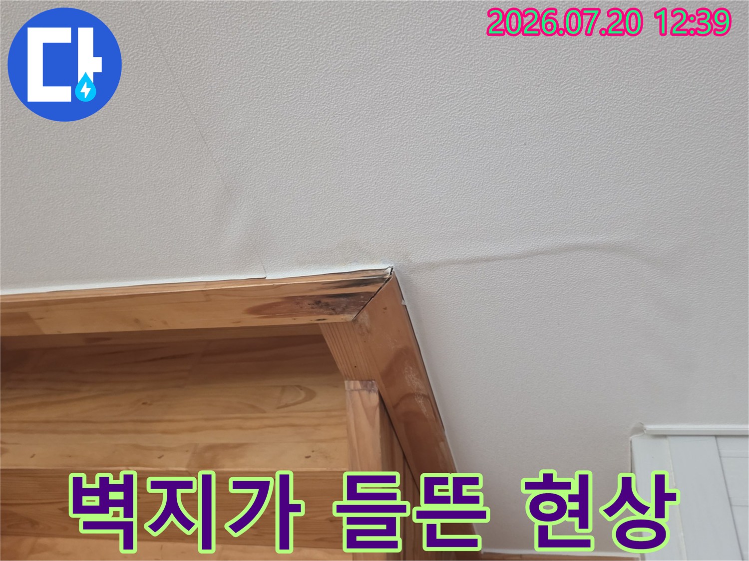 나무 선반 윗부분의 흰색 실크벽지가 물기로 인해 볼록하게 부풀어 오른 모습