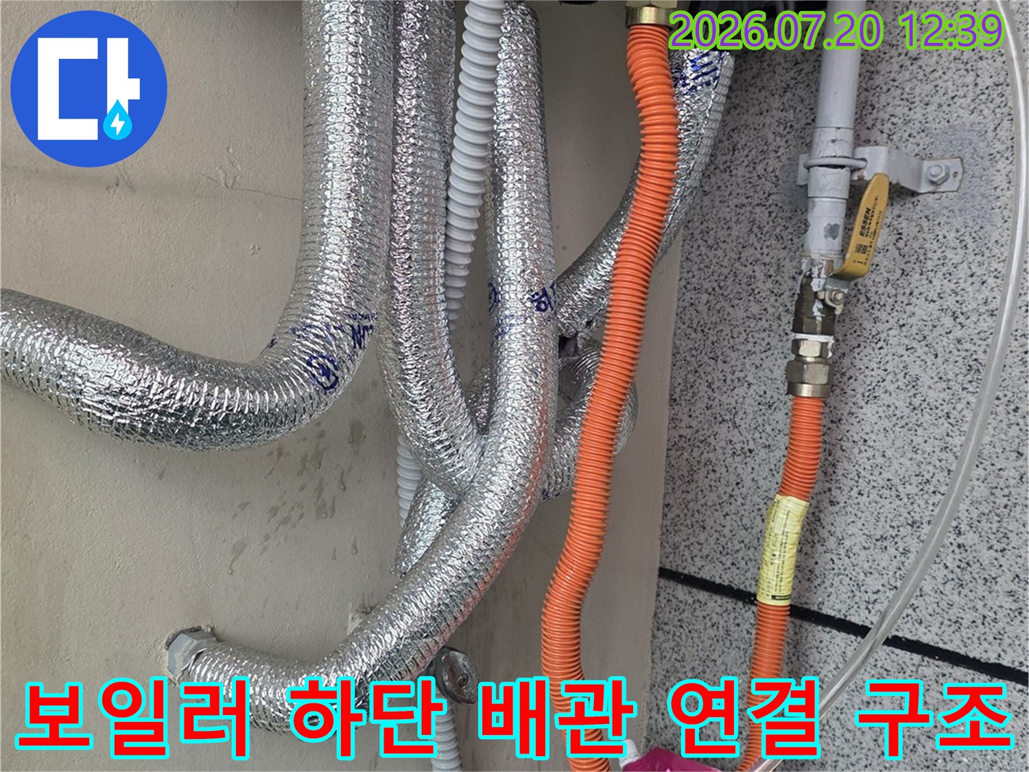 보일러 본체 밑으로 은색 단열재 관과 주황색 호스가 복잡하게-연결된 모습