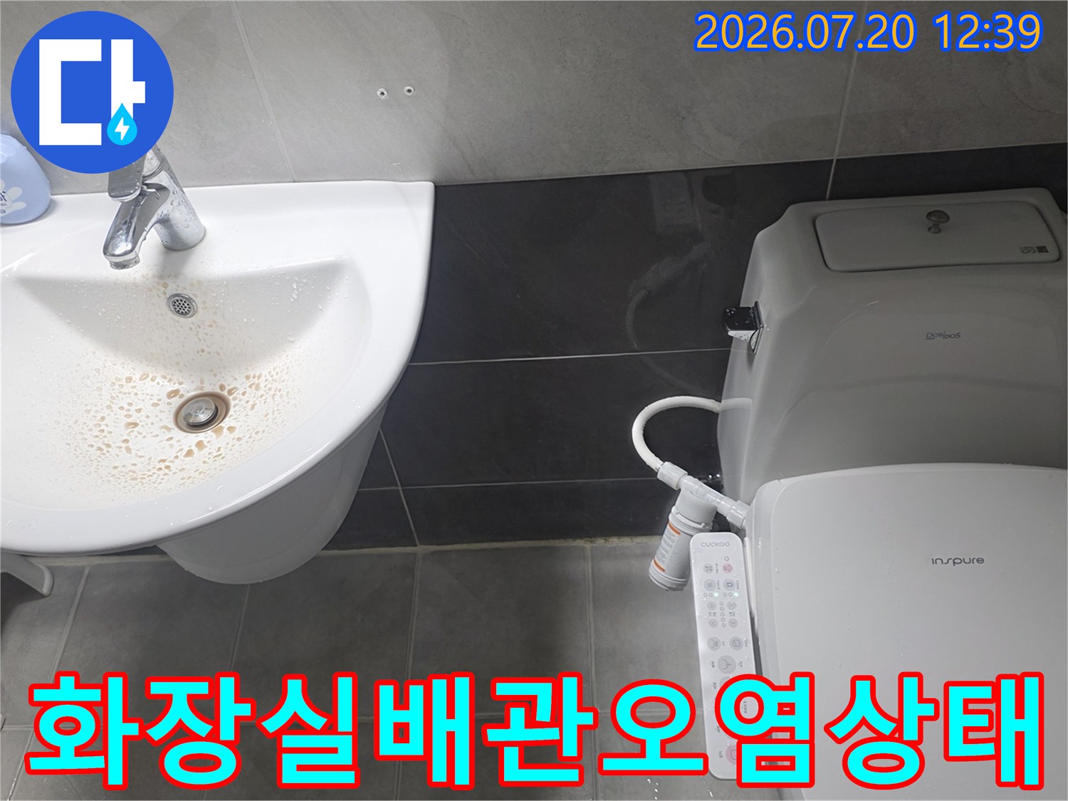세면대-배수구 주변의 갈색 침전물과-옆에 놓인-비데 변기의 전경