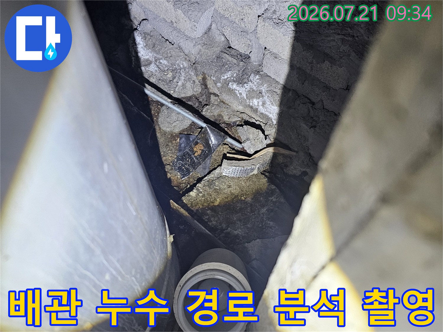 누수가 발생하는 배관 연결부와 주변 균열 부위를 근접 촬영한 사진
