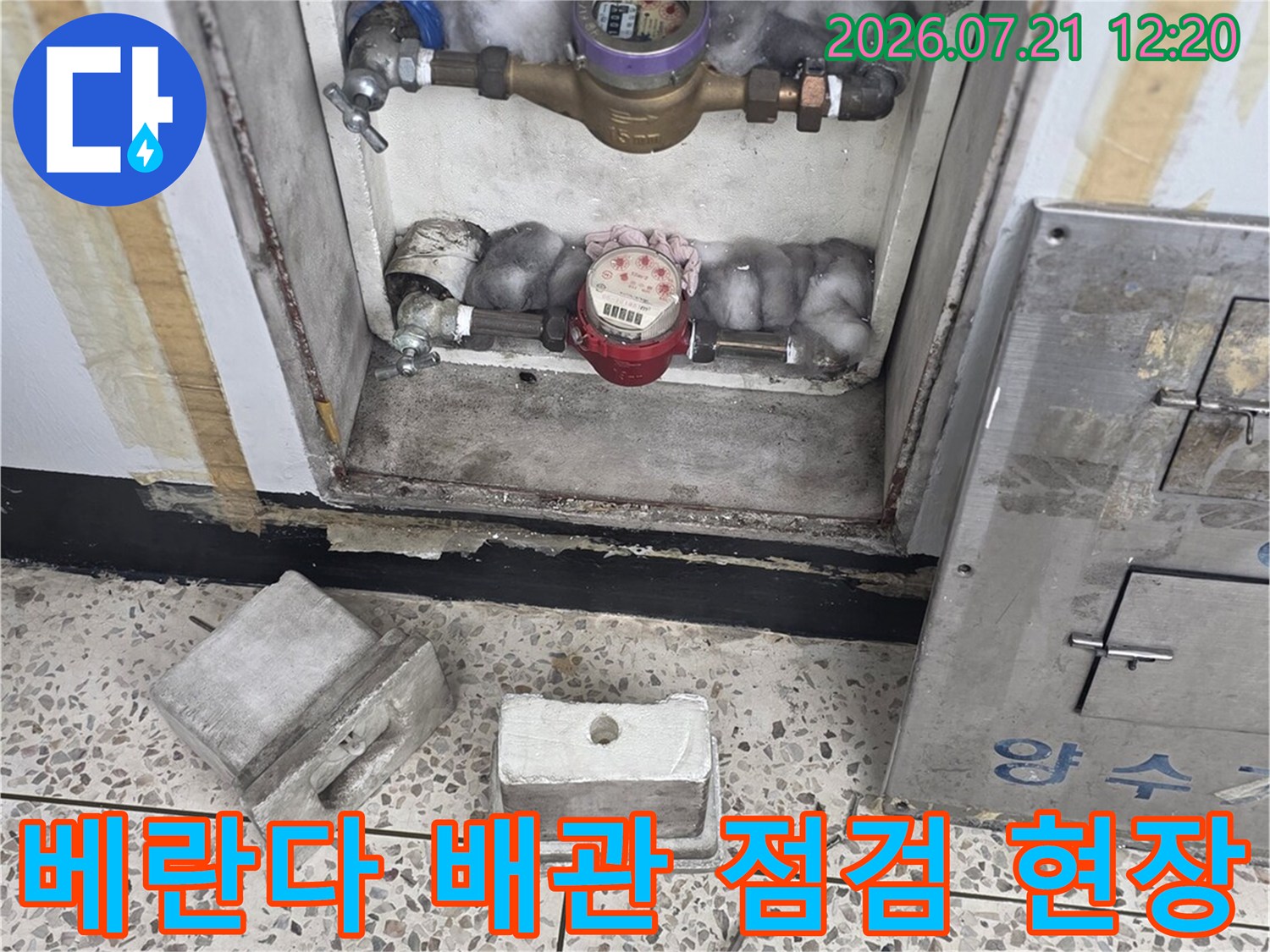 베란다 내부 노출된 수도 배관과 공압 점검을 위한 장비가 놓인 현장 모습