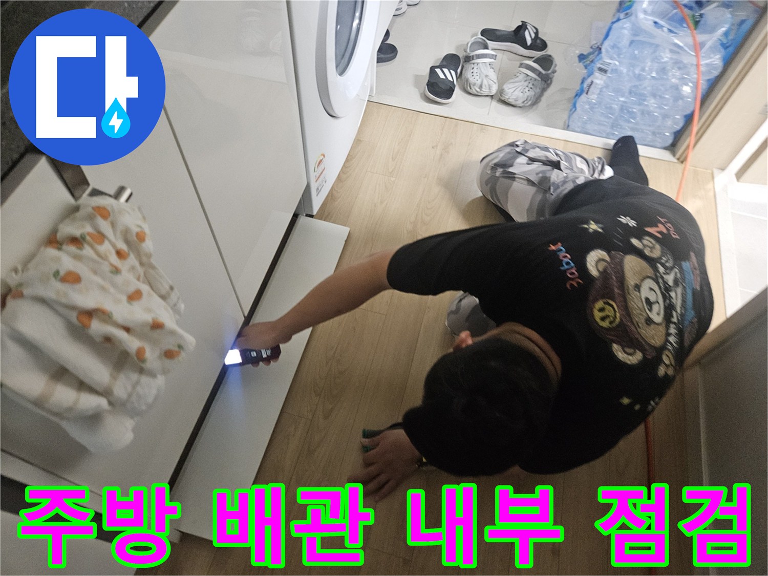 손전등을-사용하여-싱크대-하단-배관-틈새를-조사하는-엔지니어