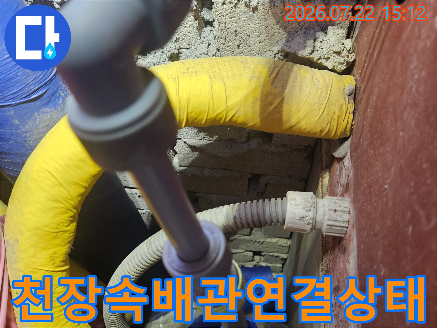 천장-내부에-설치된-회색-플라스틱-관과-노란색-보온재-처리된-배관의-교차-지점