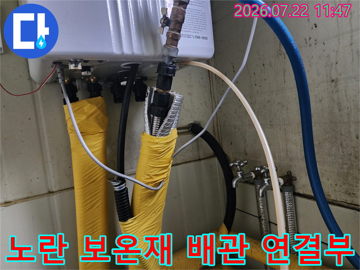 보일러 하단에 설치된 노란색 단열재 배관과 금속 연결 부품들의 상세 사진