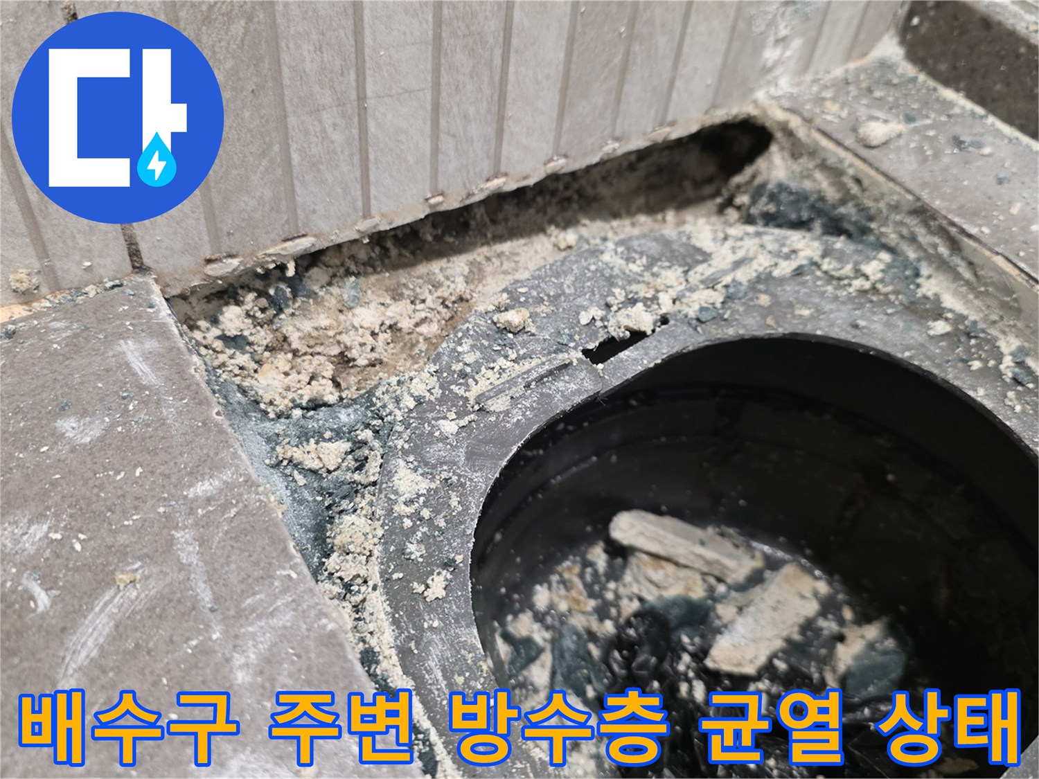배수관 주변의 깨진 방수층과 젖은 모래층