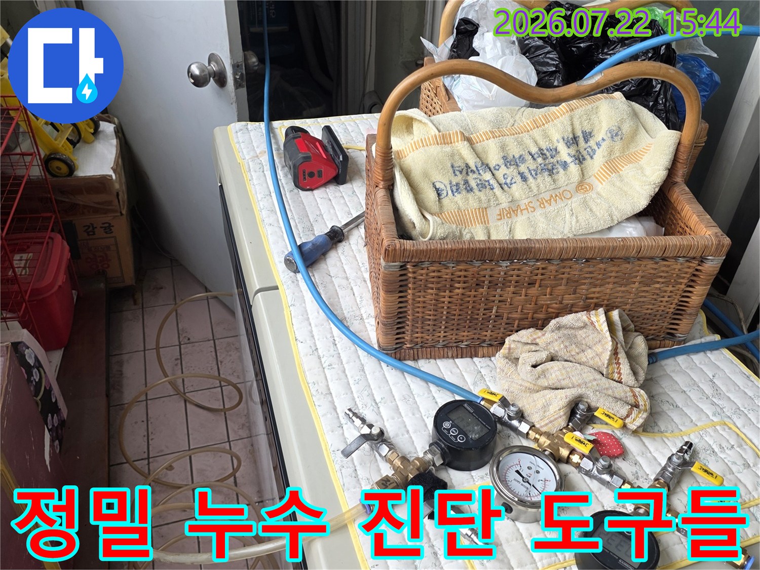 흰색 보호 패드 위에 배치된 배관 압력 측정 장비-파란색 튜브와 게이지가 연결됨
