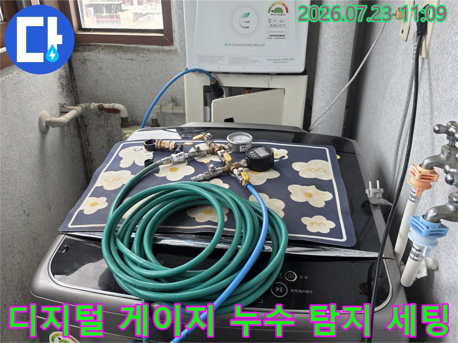 세탁기 상단에 배치된 파란색 호스와 디지털 압력 측정 장치-현장 검사 중