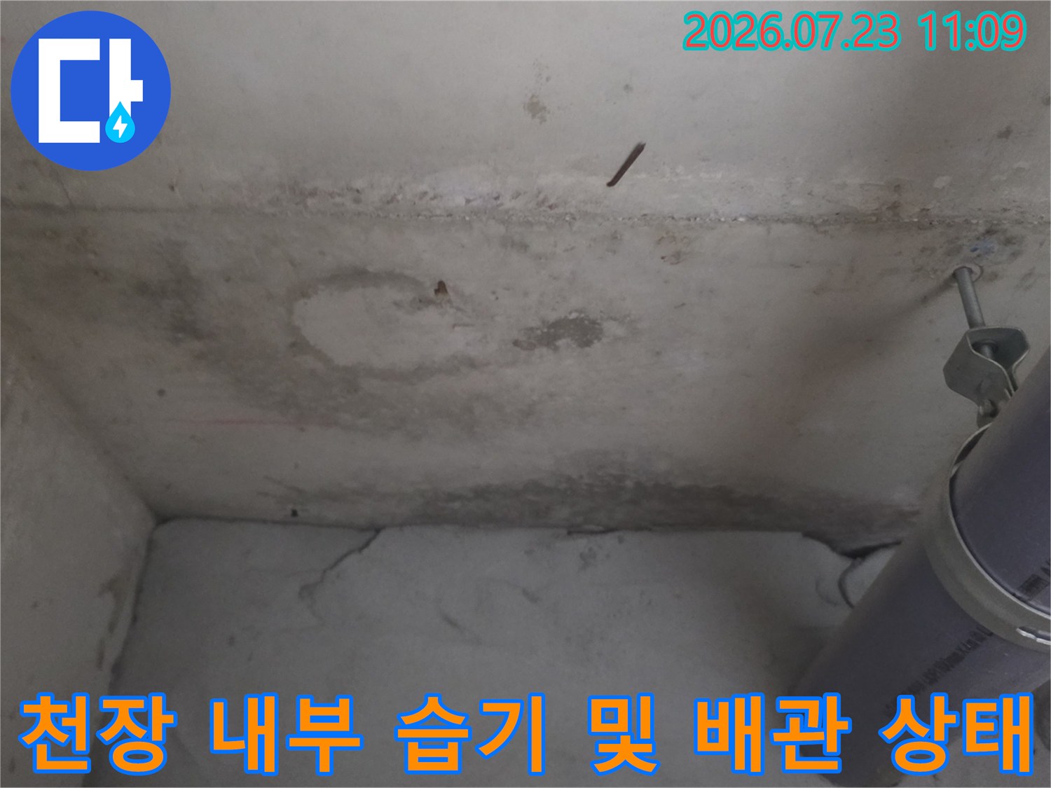 습기가 스며들어 얼룩진 천장 벽면과 회색 PVC 배관-누수 진단 사진