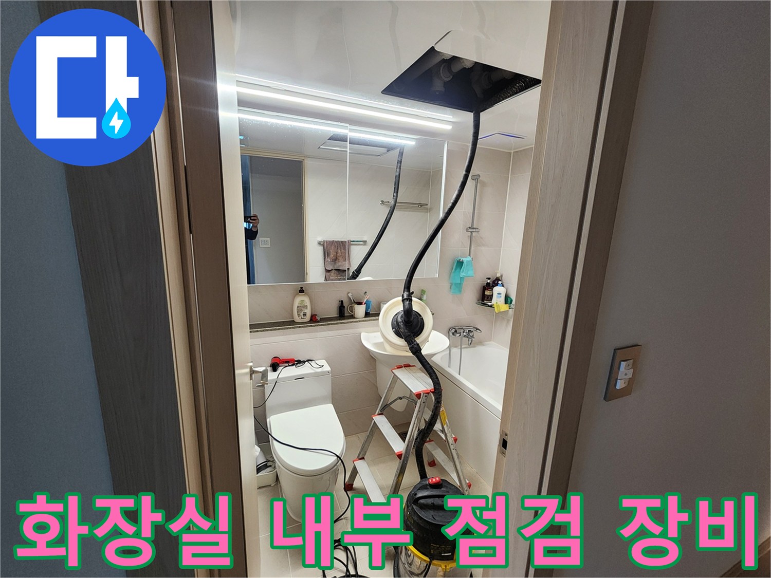 점검 작업 중인-사다리와 청소기 장비가 있는 욕실 모습