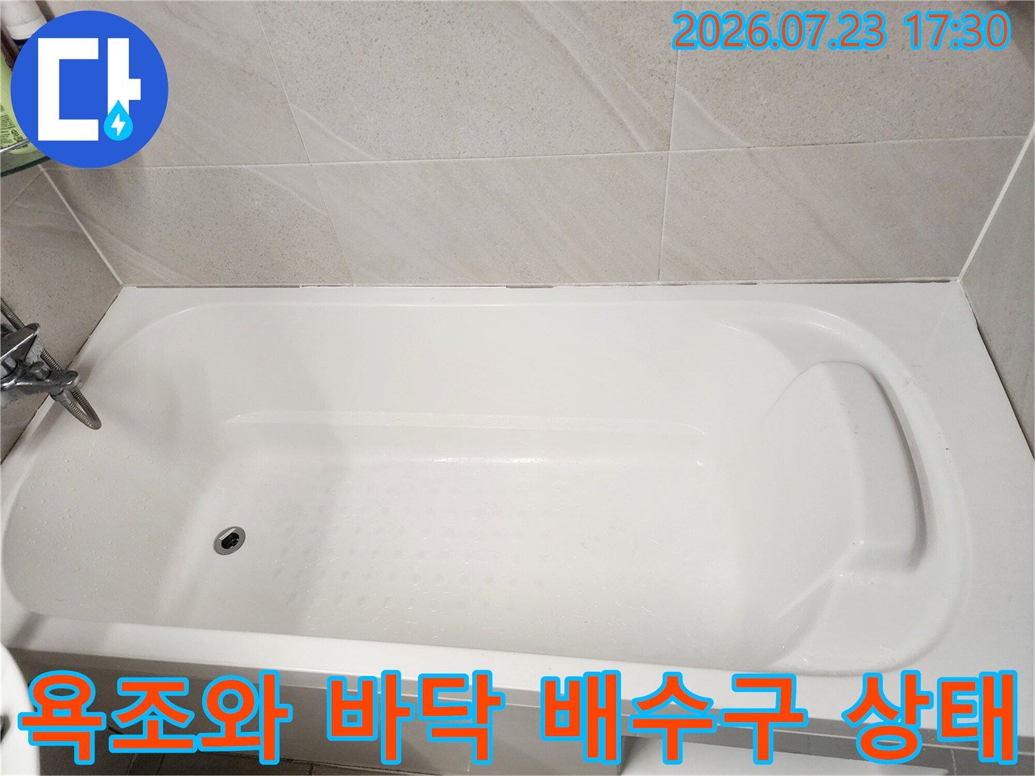 흰색 욕조 내부의 배수구-홀과 주변 타일 마감 상태 사진