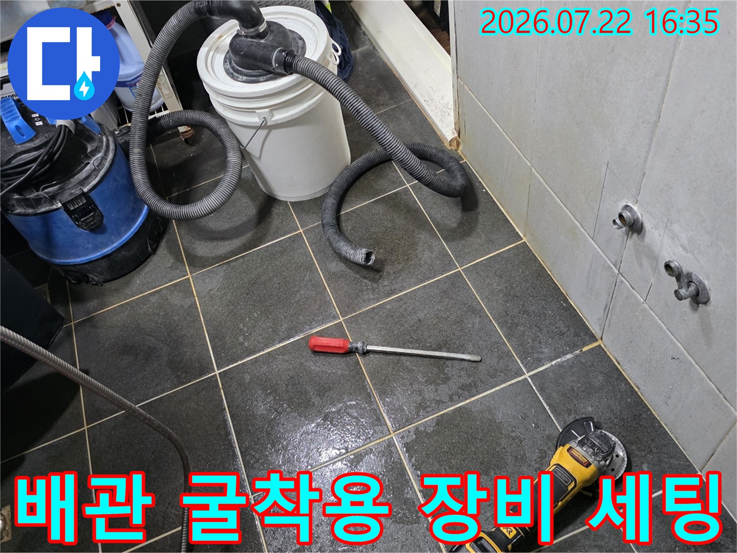 누수 지점을 파내기 위해 준비된 전동 공구와 청소기가 놓인 다용도실 바닥