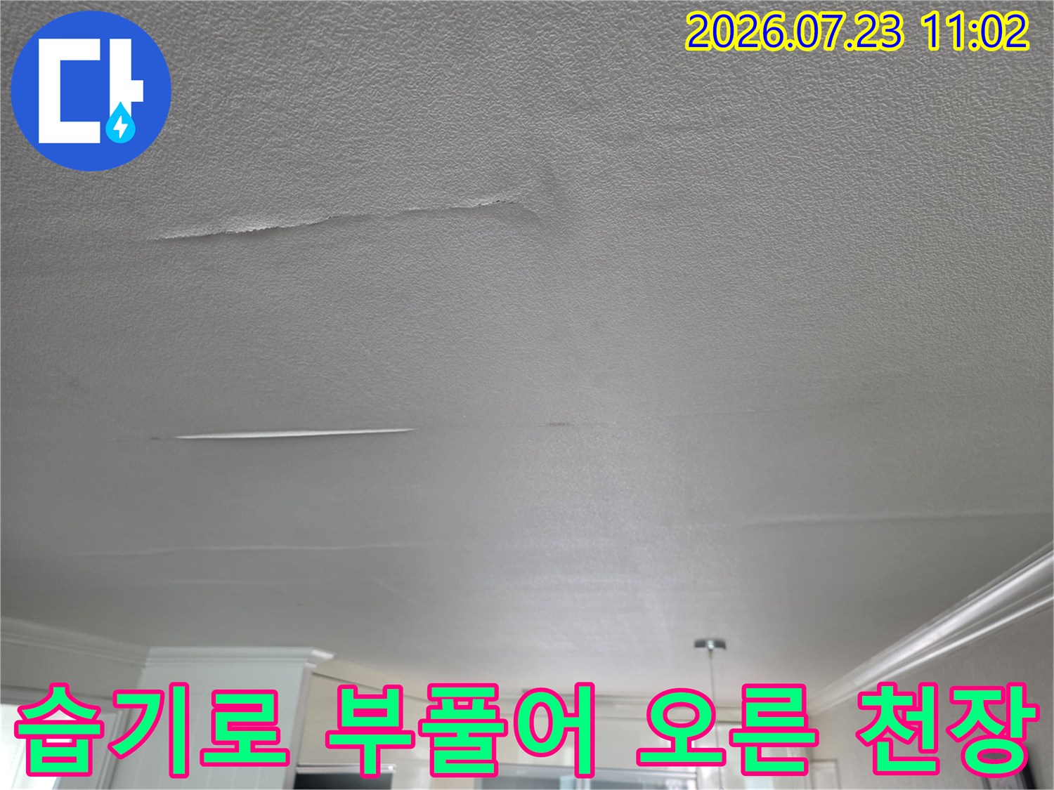 누수로-인해-거실-천장의-마감재가-부분적으로-손상되고-들떠있는-모습