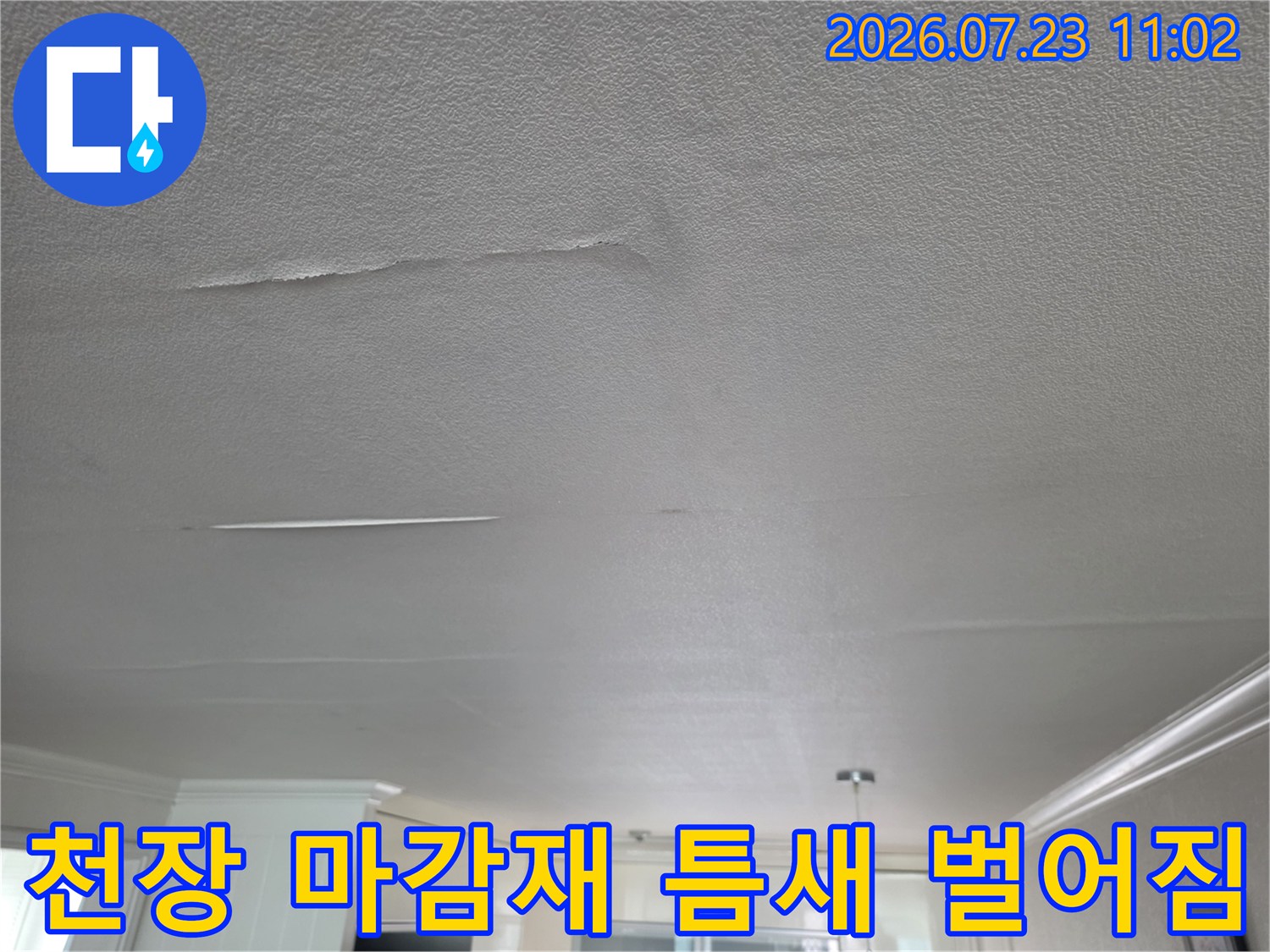 물 유입으로 인하여 거실 천장의 하얀색 표면이 들뜨고 갈라진 모습