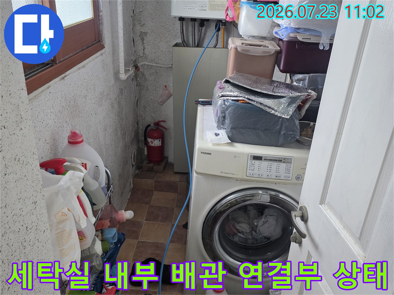 파란색 급수 호스가 연결된 세탁기와 보일러-주변 정리 상태와 누수 여부 확인
