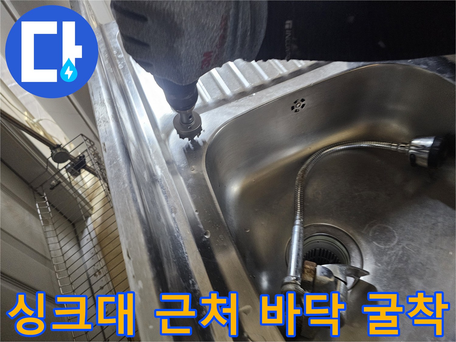 스테인리스 싱크대 볼 옆에서 배관 점검을 위해 드릴링하는 모습