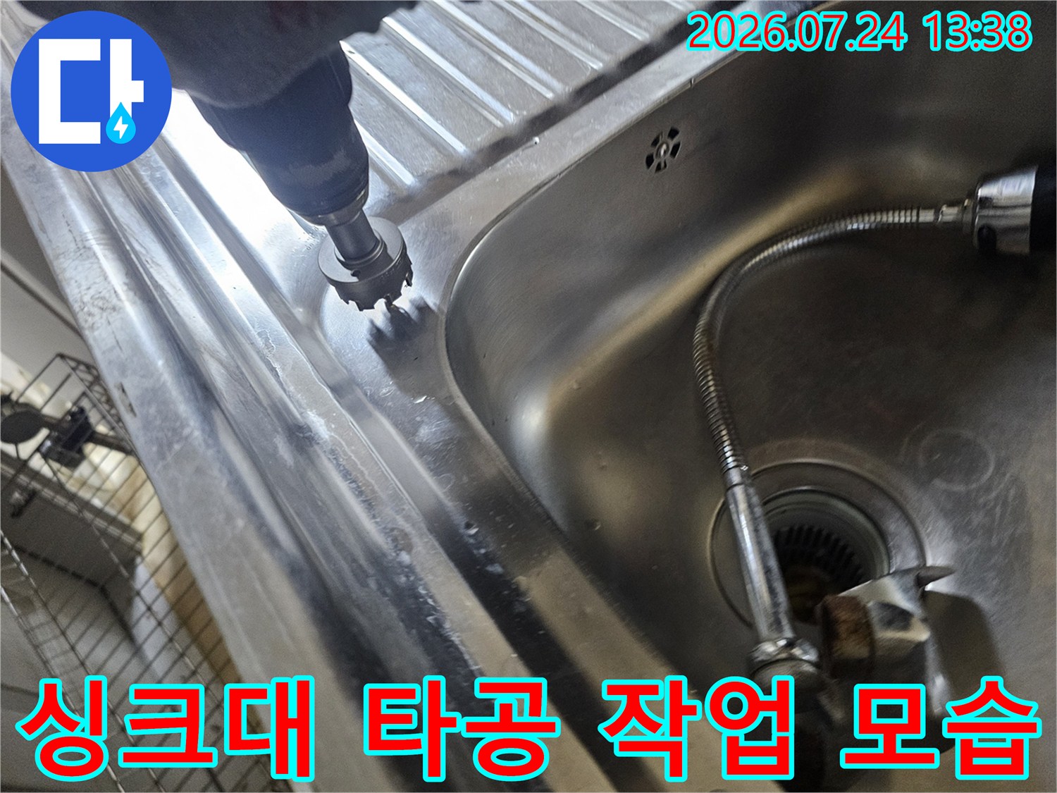 싱크대 상판 부근에 전동 드릴 장비를 사용하여 구멍을 뚫고 있는 작업 장면