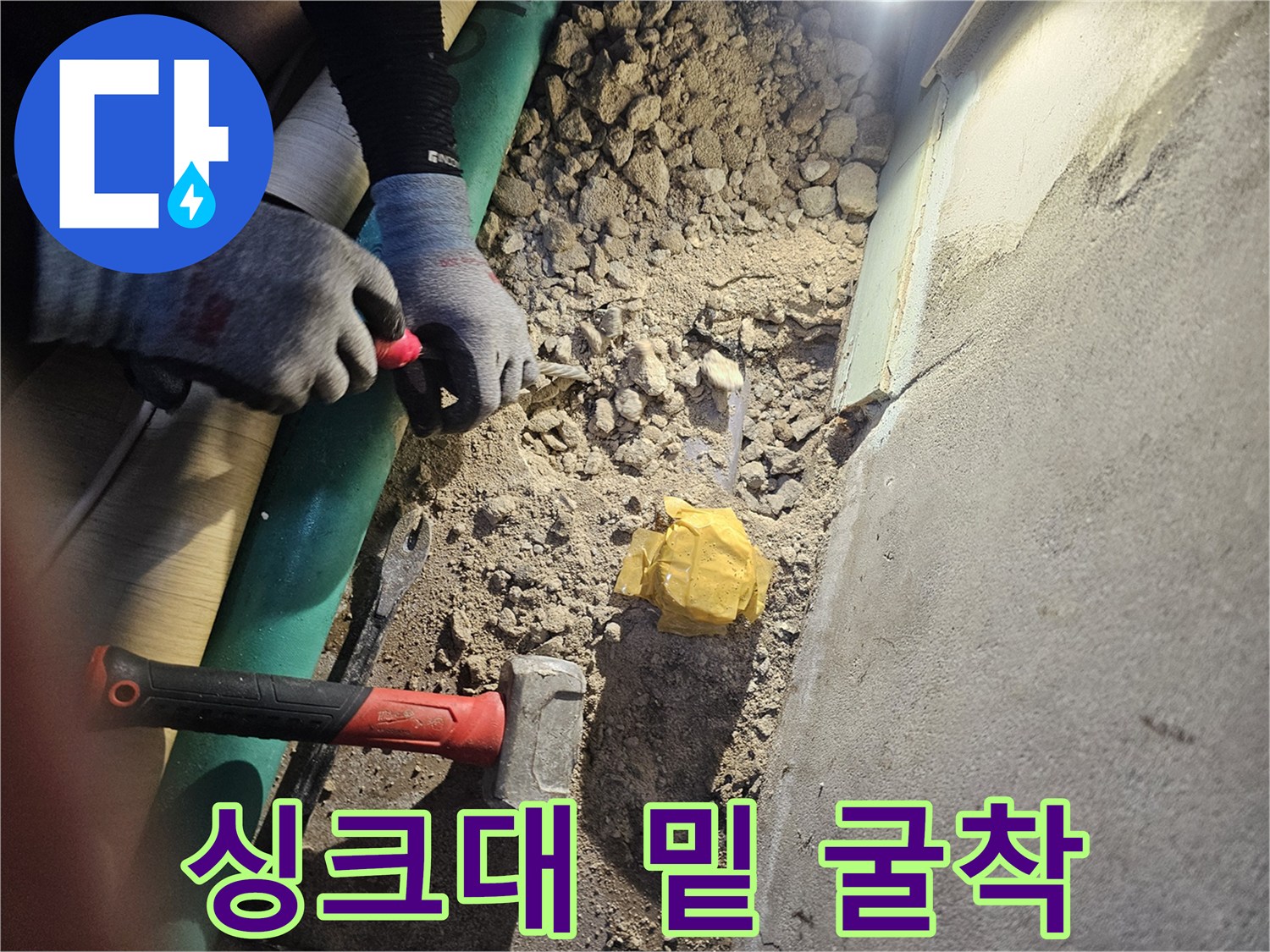 파헤쳐진 바닥면과 작업용 망치가 놓여 있는 현장 사진입니다.