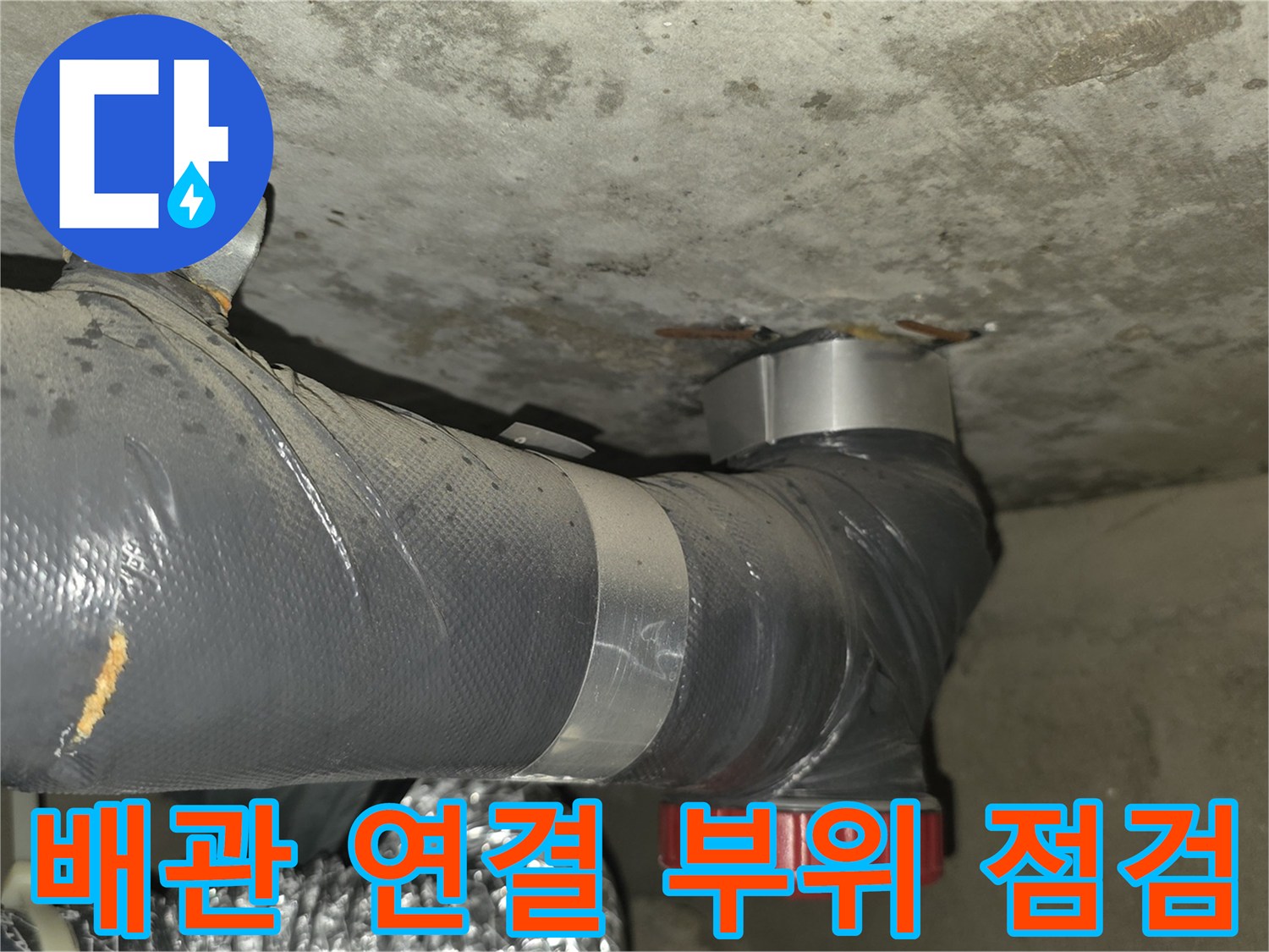 천장 내부 배관-연결부의 노후된 상태와 습기 침투 흔적을 촬영한 이미지