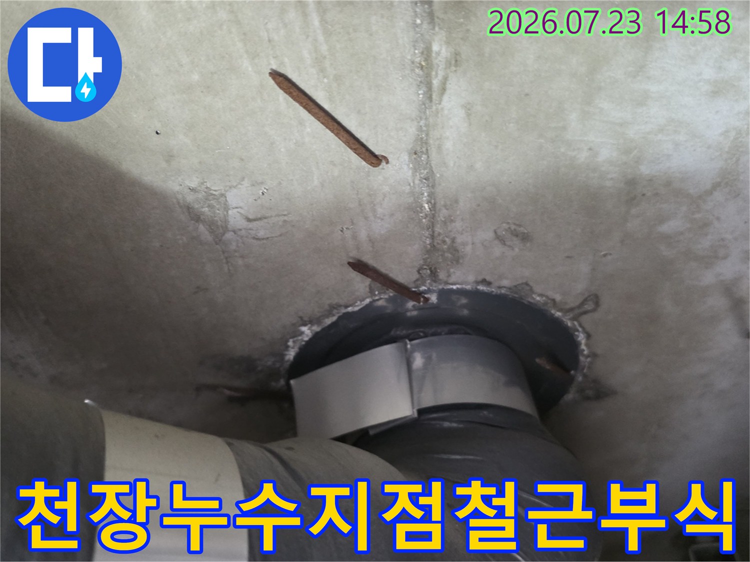 흰색 천장 슬라브 속에 배관이 설치되어 있고 주변 철근이 부식된 장면