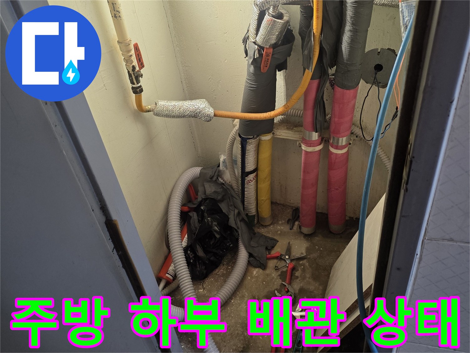 복잡하게 얽힌 주방 배관과 누수 진단용 장비가 놓여 있는 현장 모습입니다.