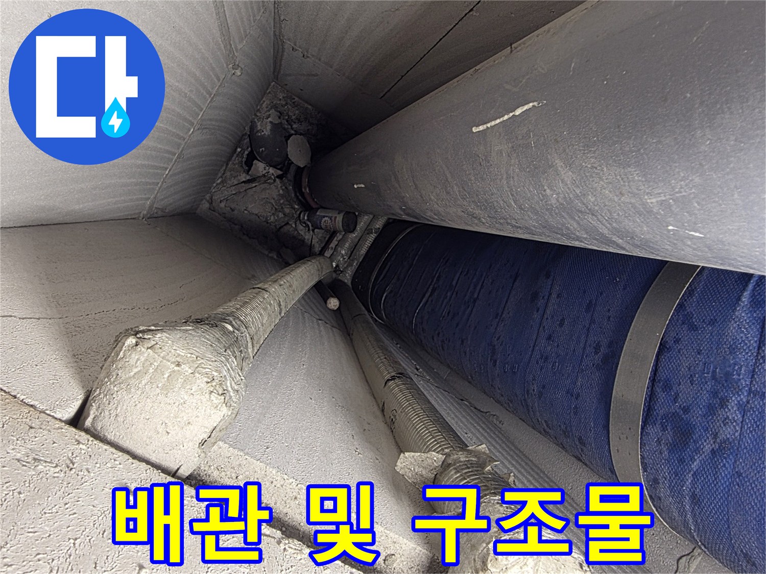천장 내부의 굵은 배관과 지지 구조물 사진입니다.