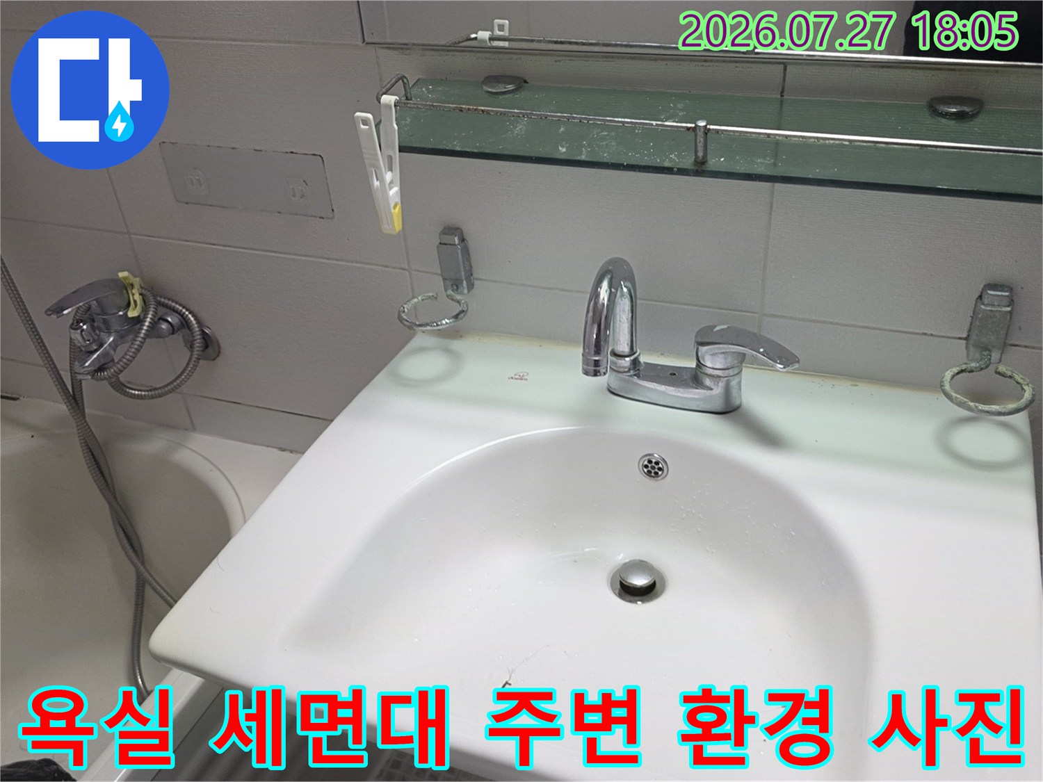 거울 아래 선반과 수전-세면대가 설치된 화장실 모습