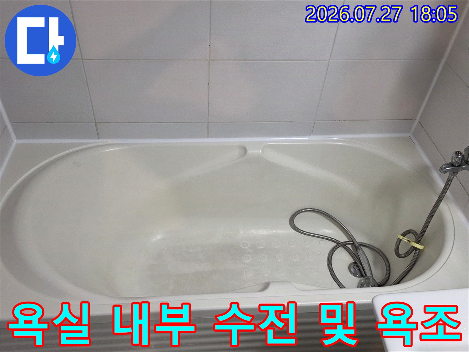 금속 재질의 샤워 수전과 흰색 아크릴 욕조가 배치된 화장실 전경