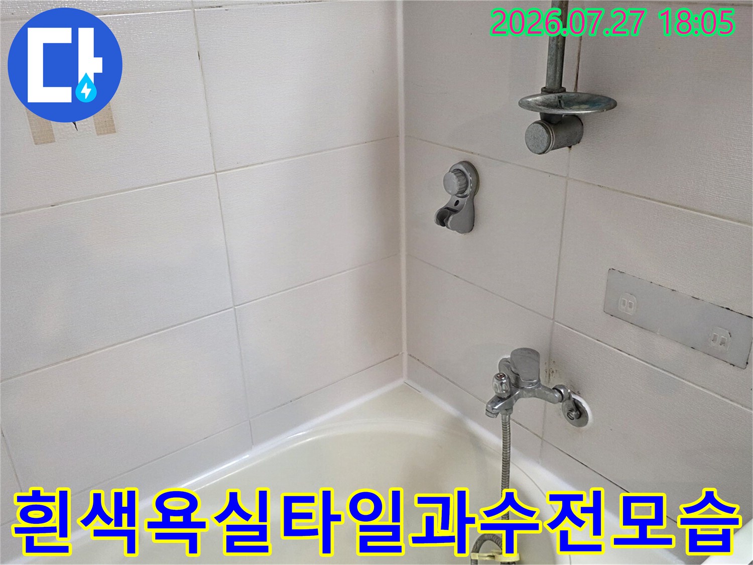 욕조 위쪽으로 설치된 샤워 수전과 벽면의 작은 장식 타일이 보이는 모습