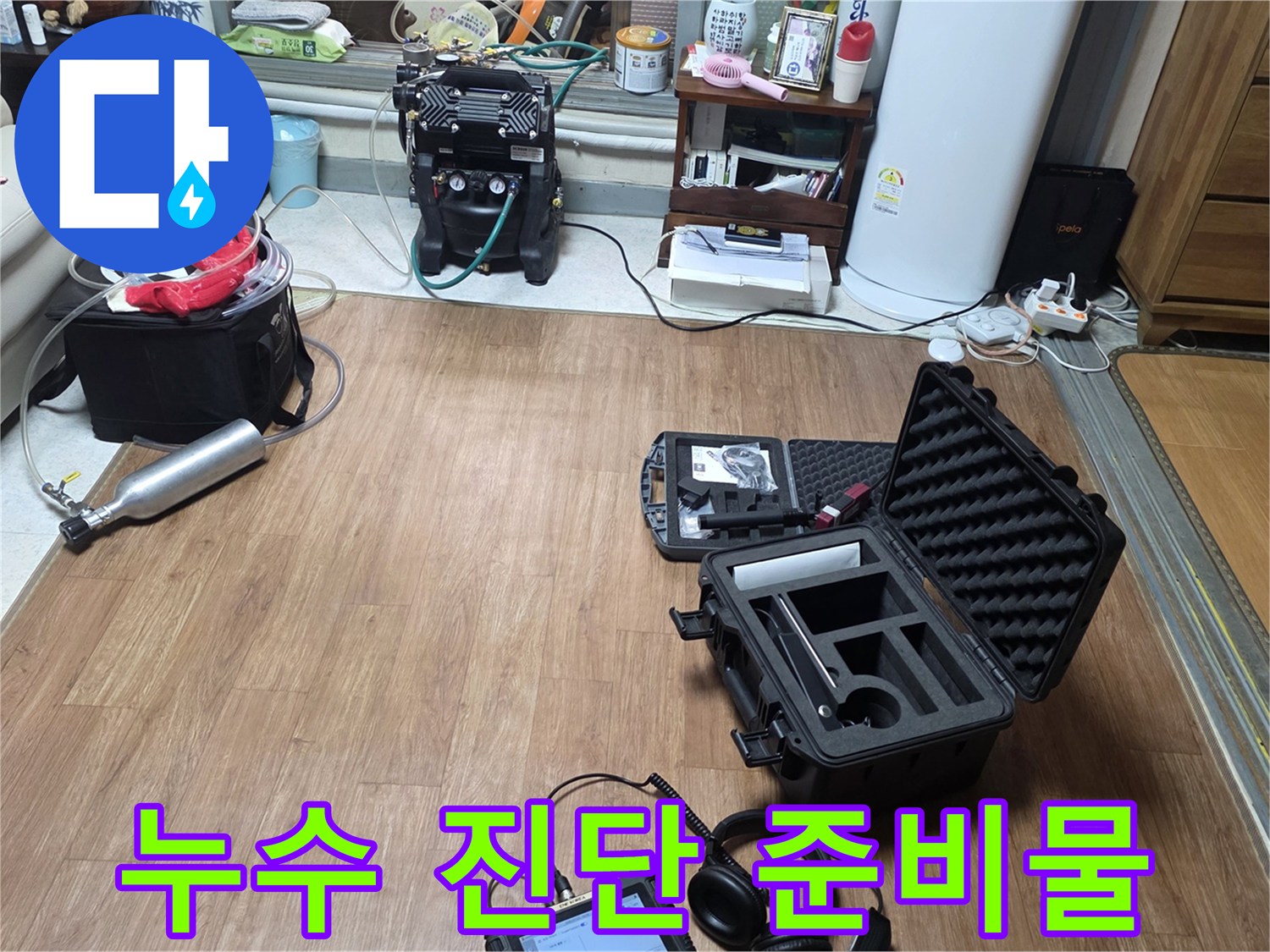 거실 바닥에 배치된 누수 탐지를 위한 전문 장비들의 모습입니다.