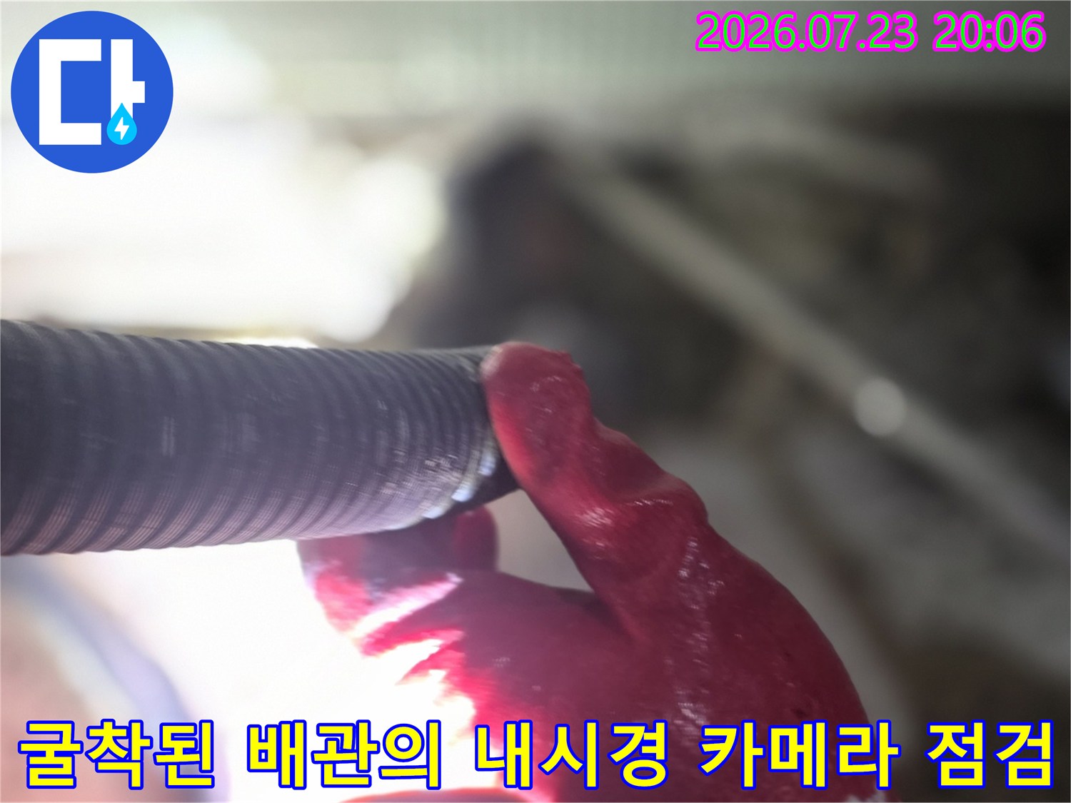 작업자가 장갑을 끼고 내시경으로 노출 배관 상태를 확인하는 모습