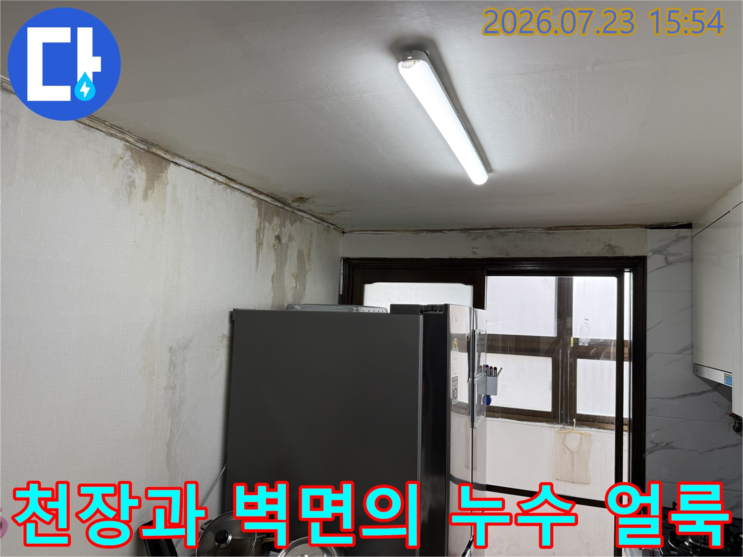 벽면 상부로 번진 누수 흔적과 천장 경계 부위 오염