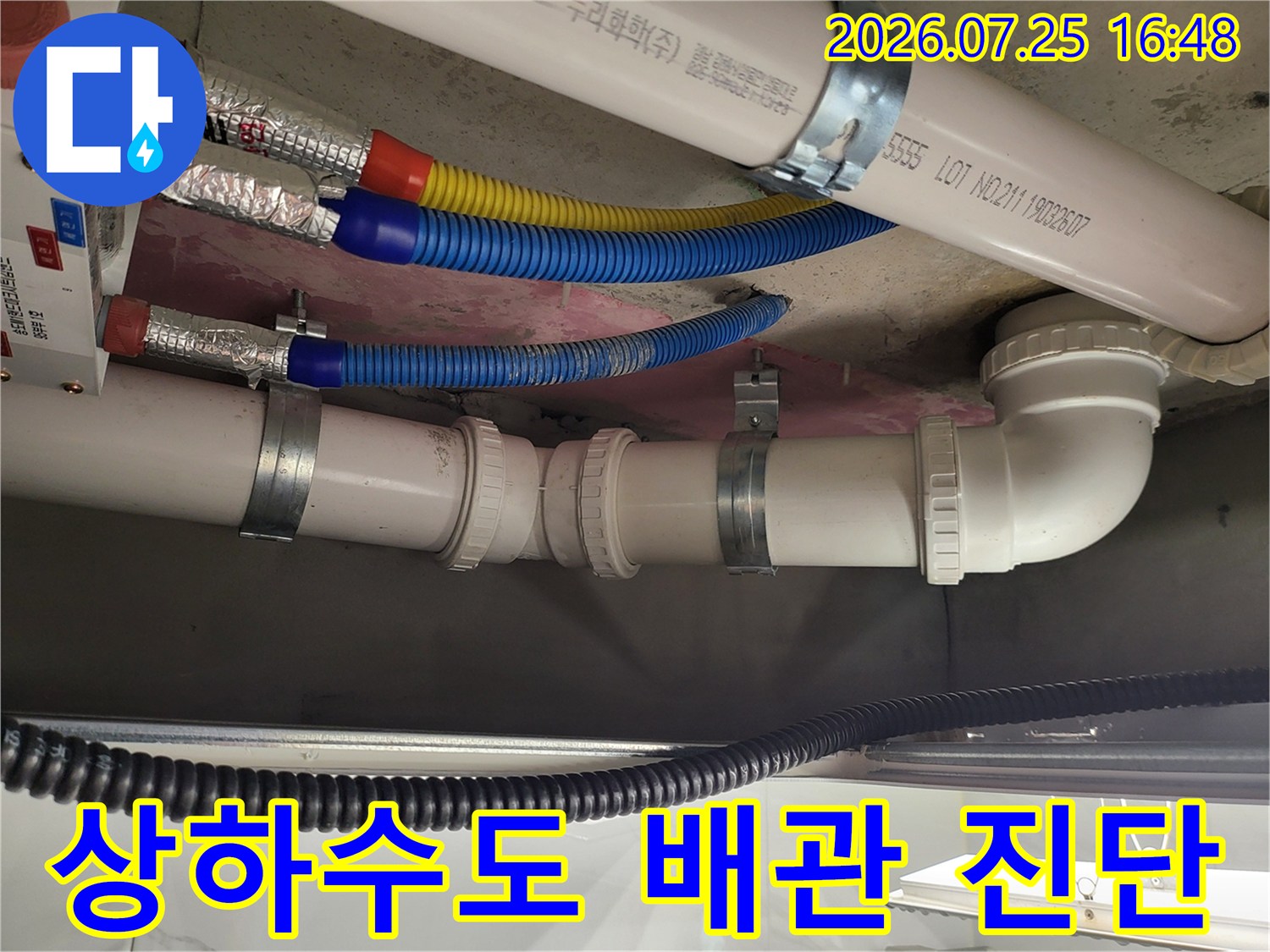 보온재 처리된 상수 배관과 흰색 오수 배관이 공존하는 천장 내부