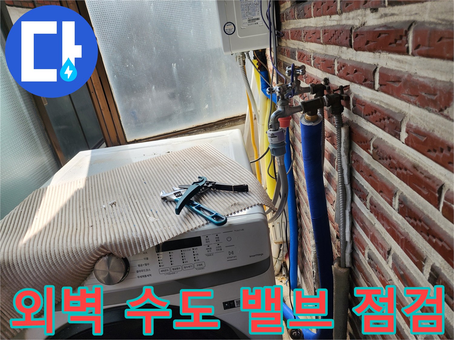 벽돌 벽면에 설치된 수도 연결 부위와 공구