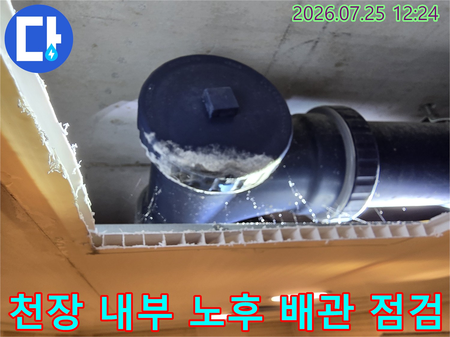 천장 내부에 노출된 오수배관의 누수 흔적과 파손 부위를 점검하는 모습