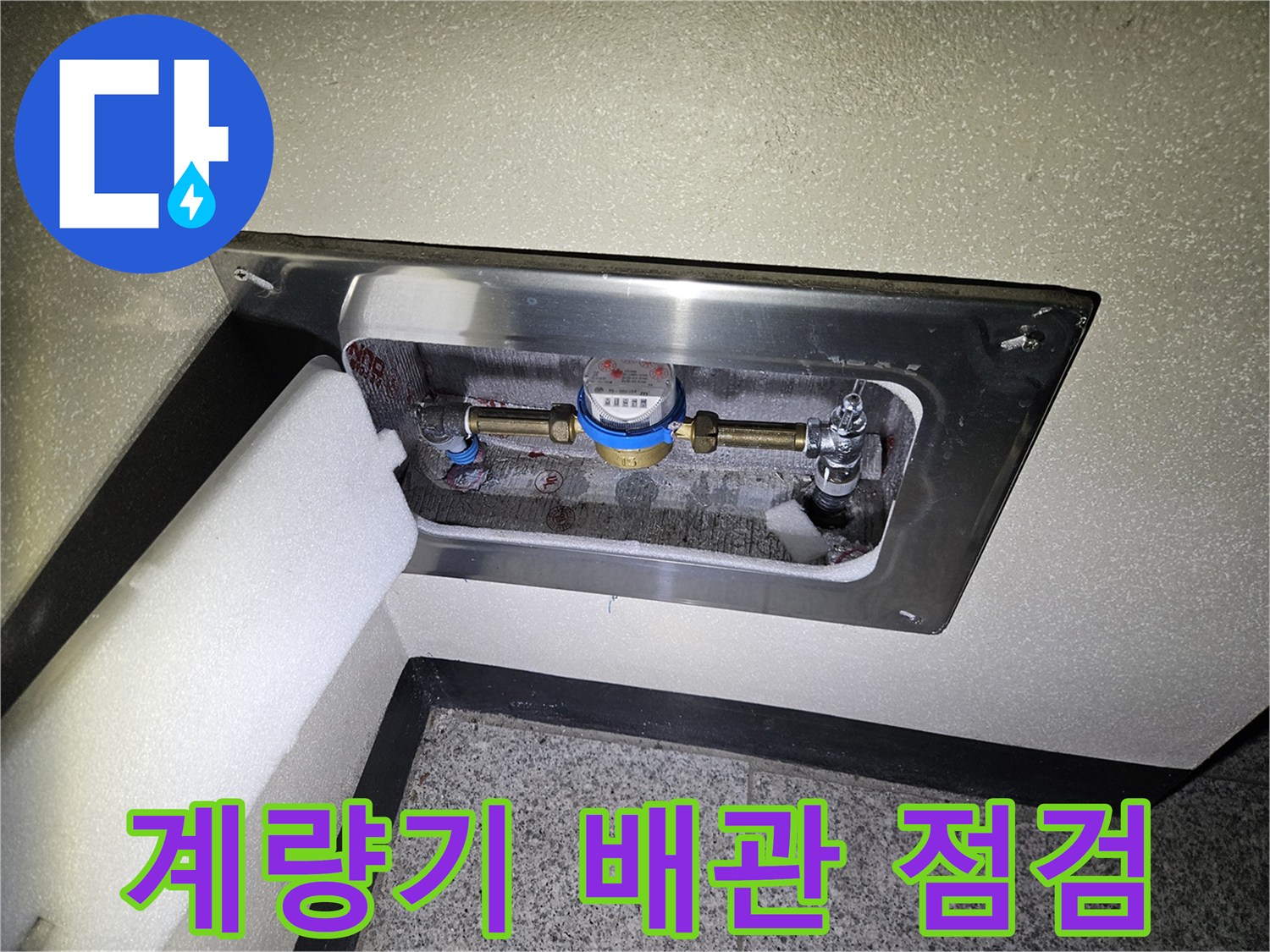 금속 덮개로 보호된 위치의 수도 계량기와 연결 배관 모습