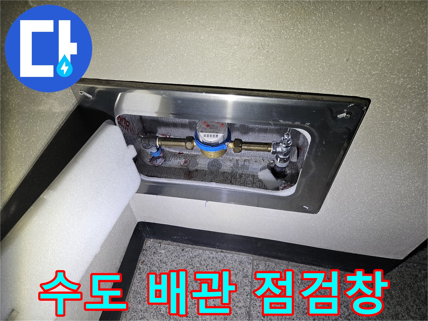 금속 판으로 마감된 벽면 내부의 수도 계량기 및 배관 구조