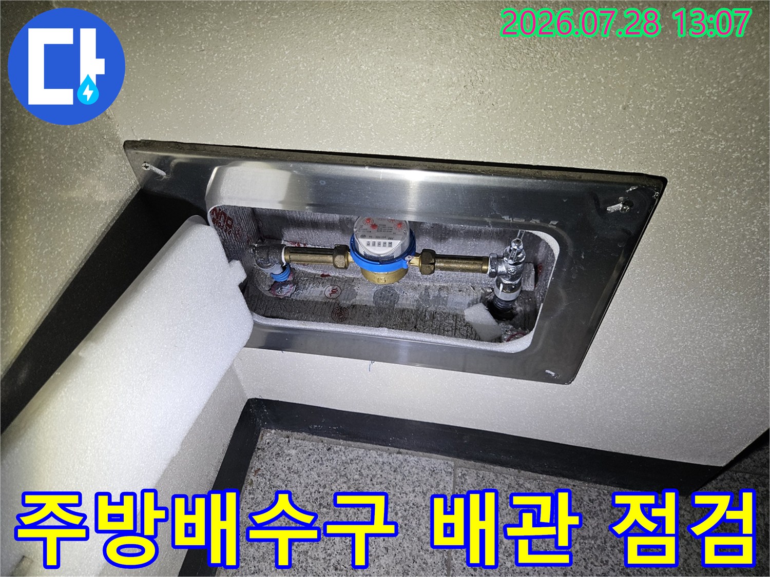 스테인리스 마감재 안쪽의 노출된 배수 배관과 밸브 구조