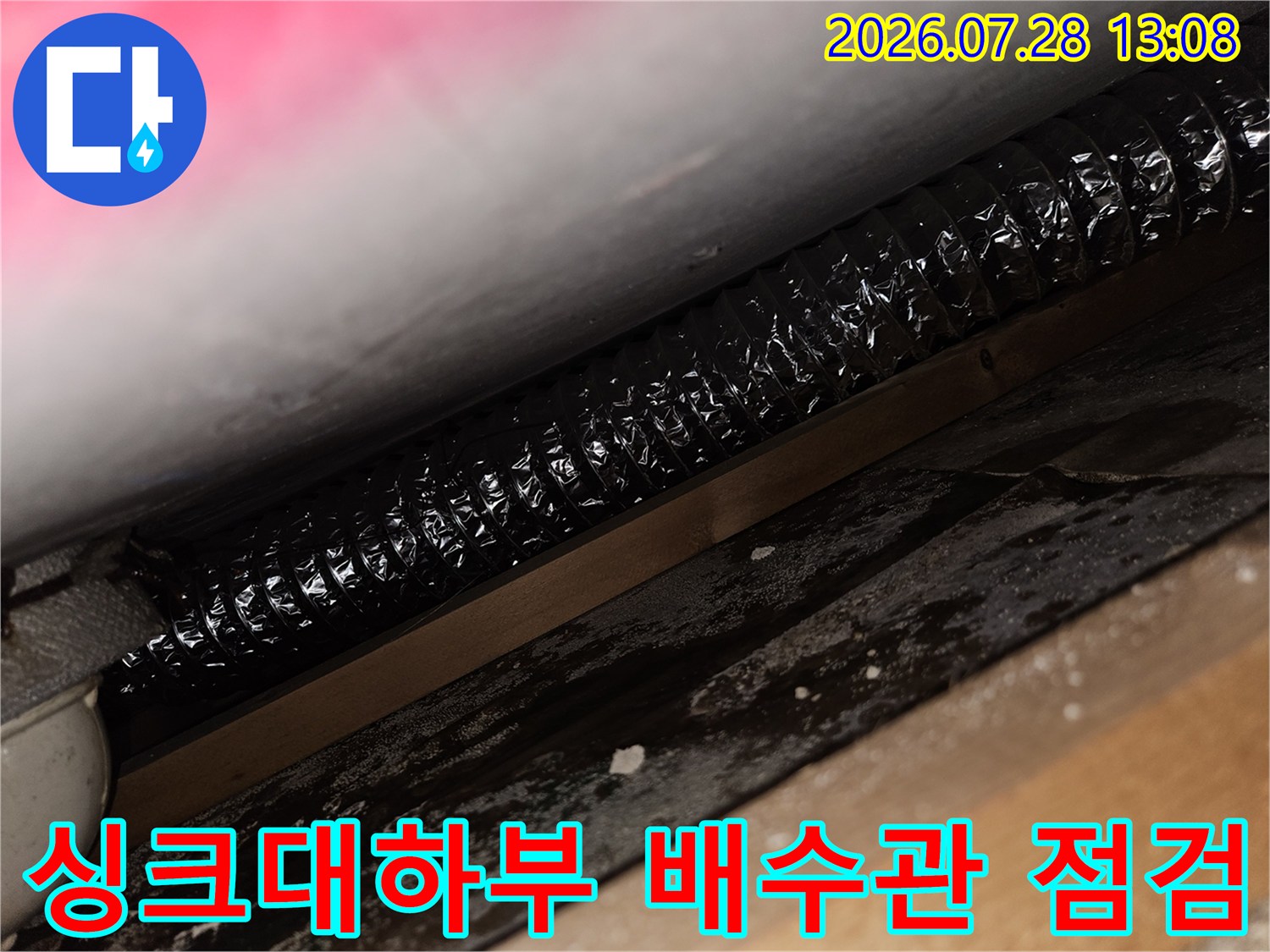 싱크대 하단부의 검은색 주름 배수 호스 및 연결 부위 점검 모습