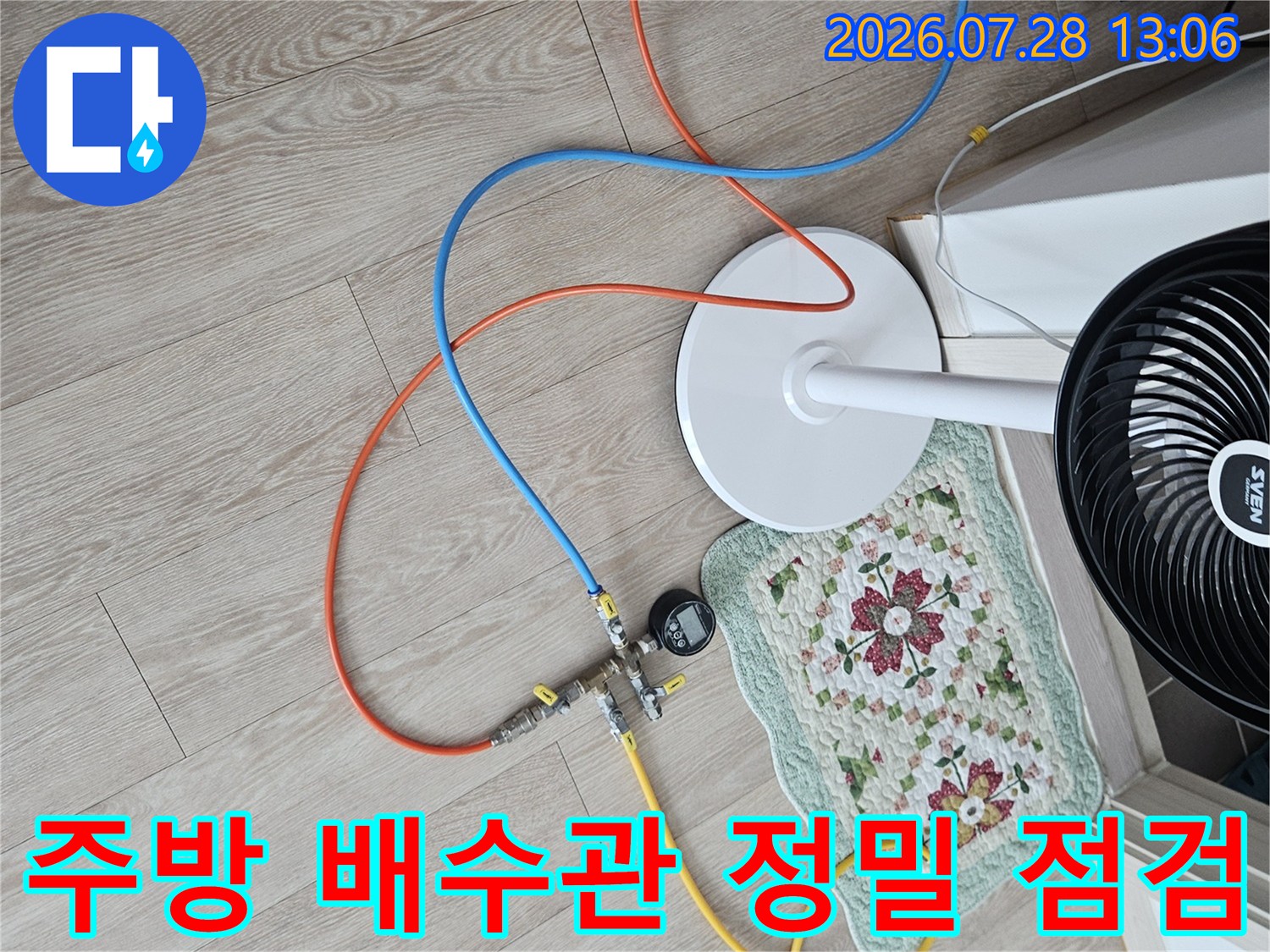 파란색과 노란색 호스를 연결하여 주방 하부 배수 배관을 세밀하게 점검하는 모습