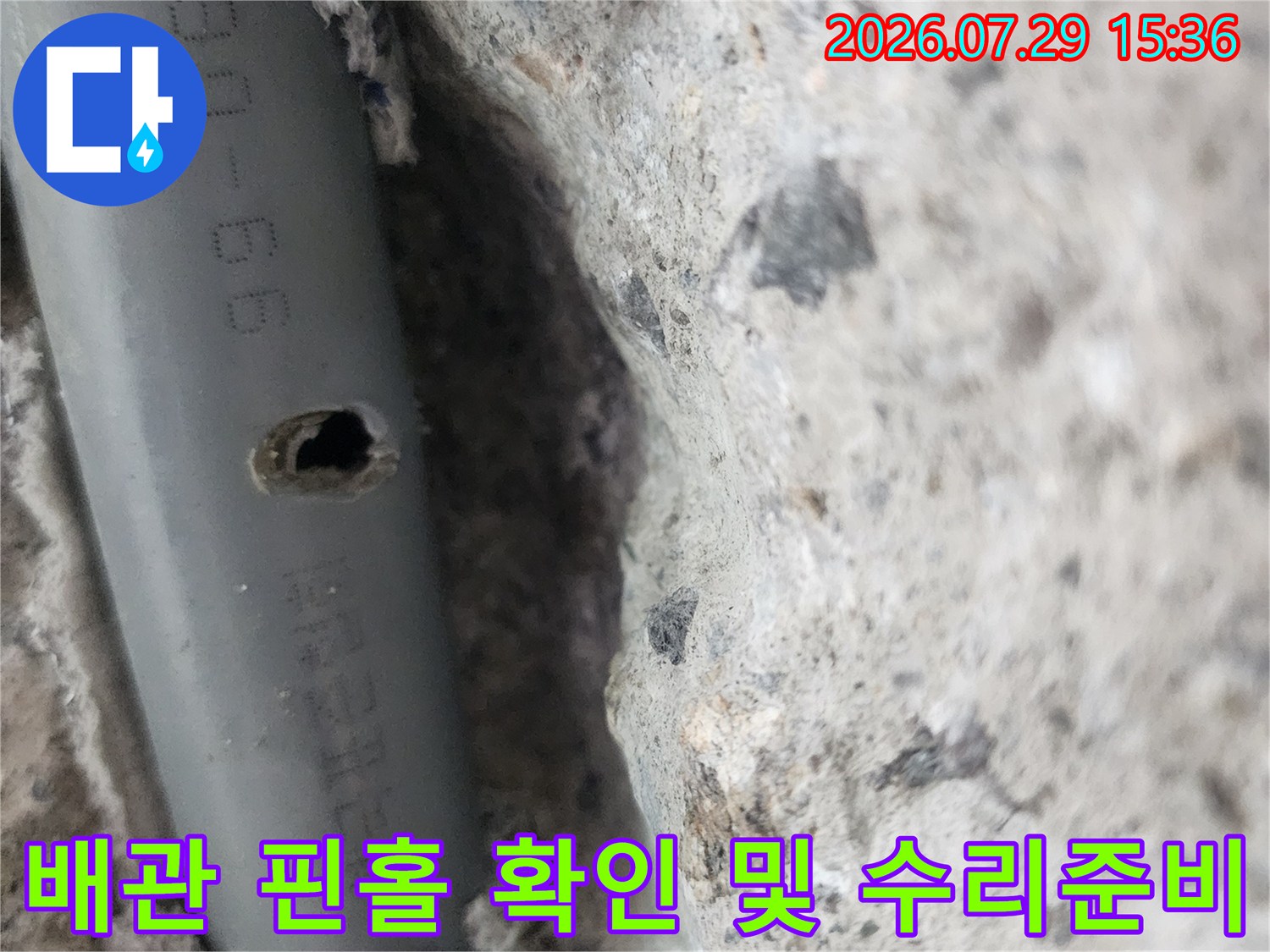 노출된 배관의 파손 부위를 촬영하여 기록한 사진입니다.